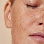 Cropped shot of the face of a young woman with freckles